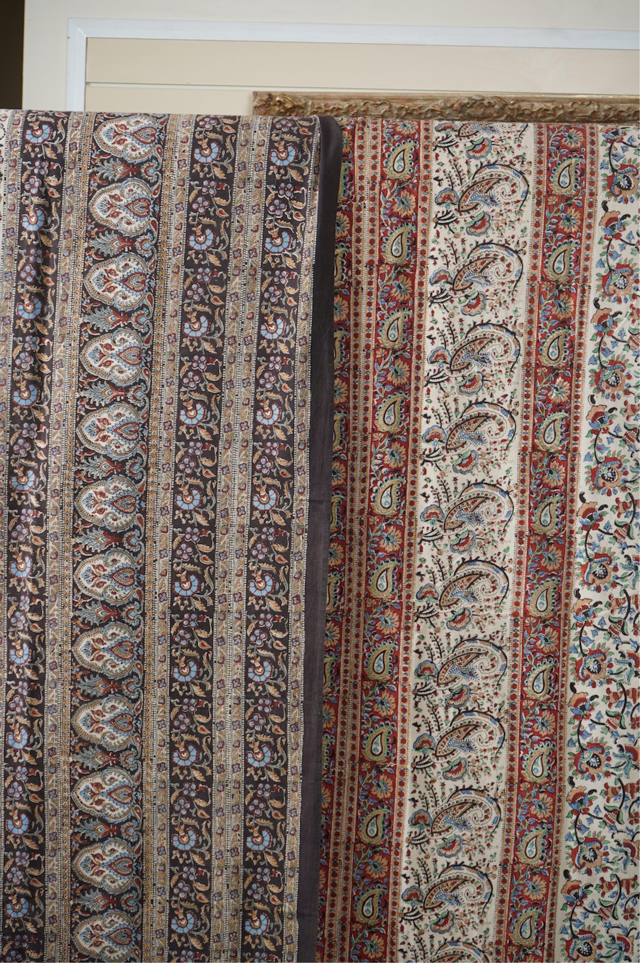 Two late 20th century large Indian block printed cotton bedcovers. One printed with brown borders, the other with brick red borders, both with large central panels designed in a classical Indian floral vining design. Bro